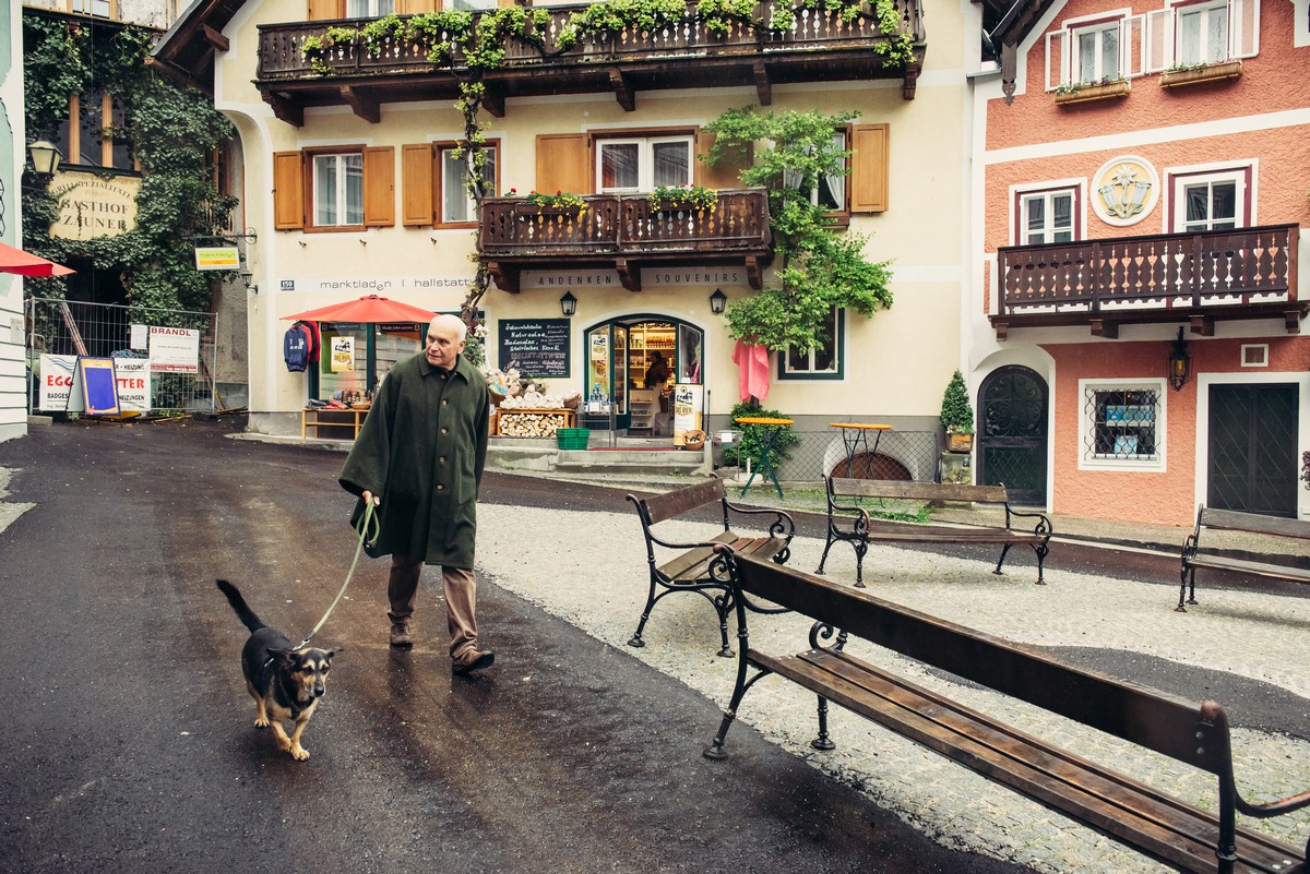 HALLSTATT, AUSTRIA - MAY 03, 2014: Local citizen on town square in Hallstatt, Austria. Hallstatt is historical village located in Austrian Alps at the Hallstatter lake and promoted by UNESCO World Heritage region.