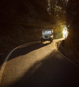 Old offroad car driving on highway inside the tunnel in the morning lighten with sunbeams in vintage tones