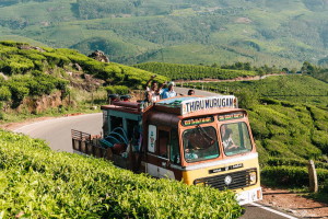 Munnar, India - December 15, 2015: Decorated truck with people in trailer going to work on tea plantations on mountain road in Munnar, India.