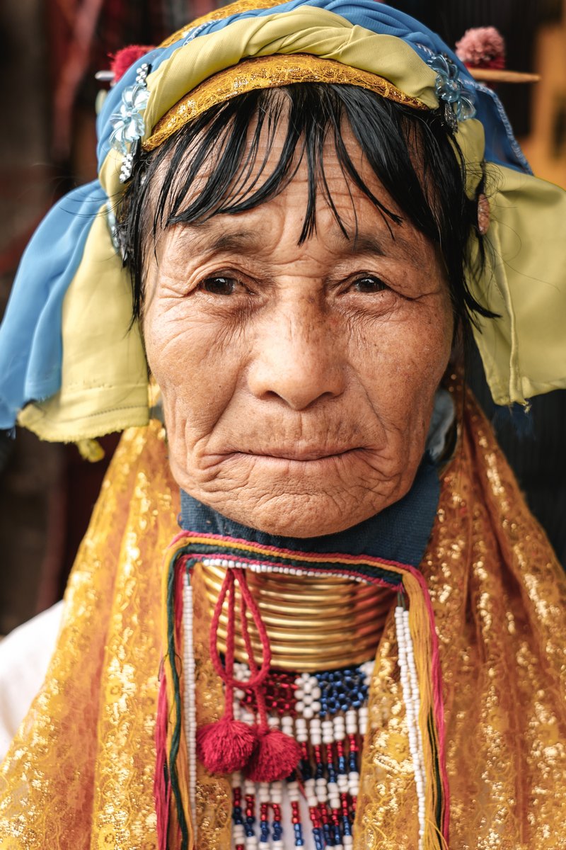 Loikaw, Myanmar - May 25, 2016: Portrait of Padaung (Karen) long neck woman in brass rings around their neck and traditional clothing on the Deenawso market