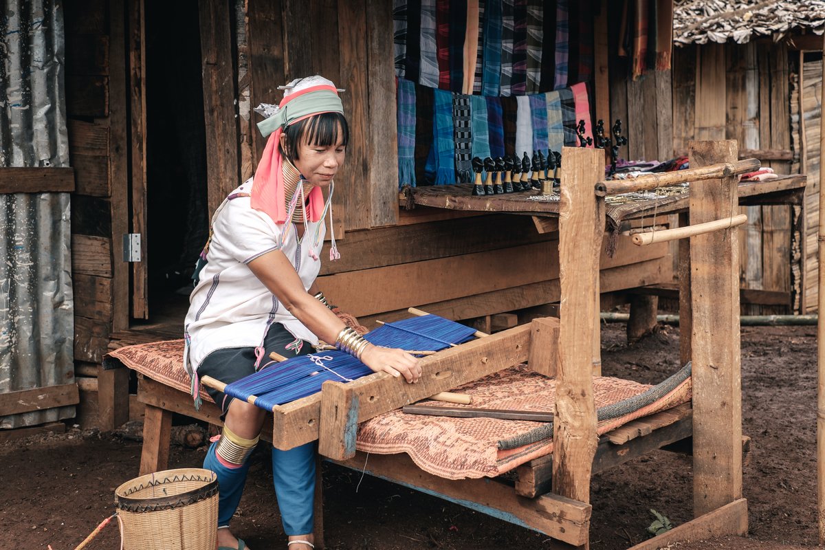 Pan Pet, Myanmar - May 25, 2016: Authentic life of Padaung (Karen) hill tribe. Karen woman doing handmade clothes