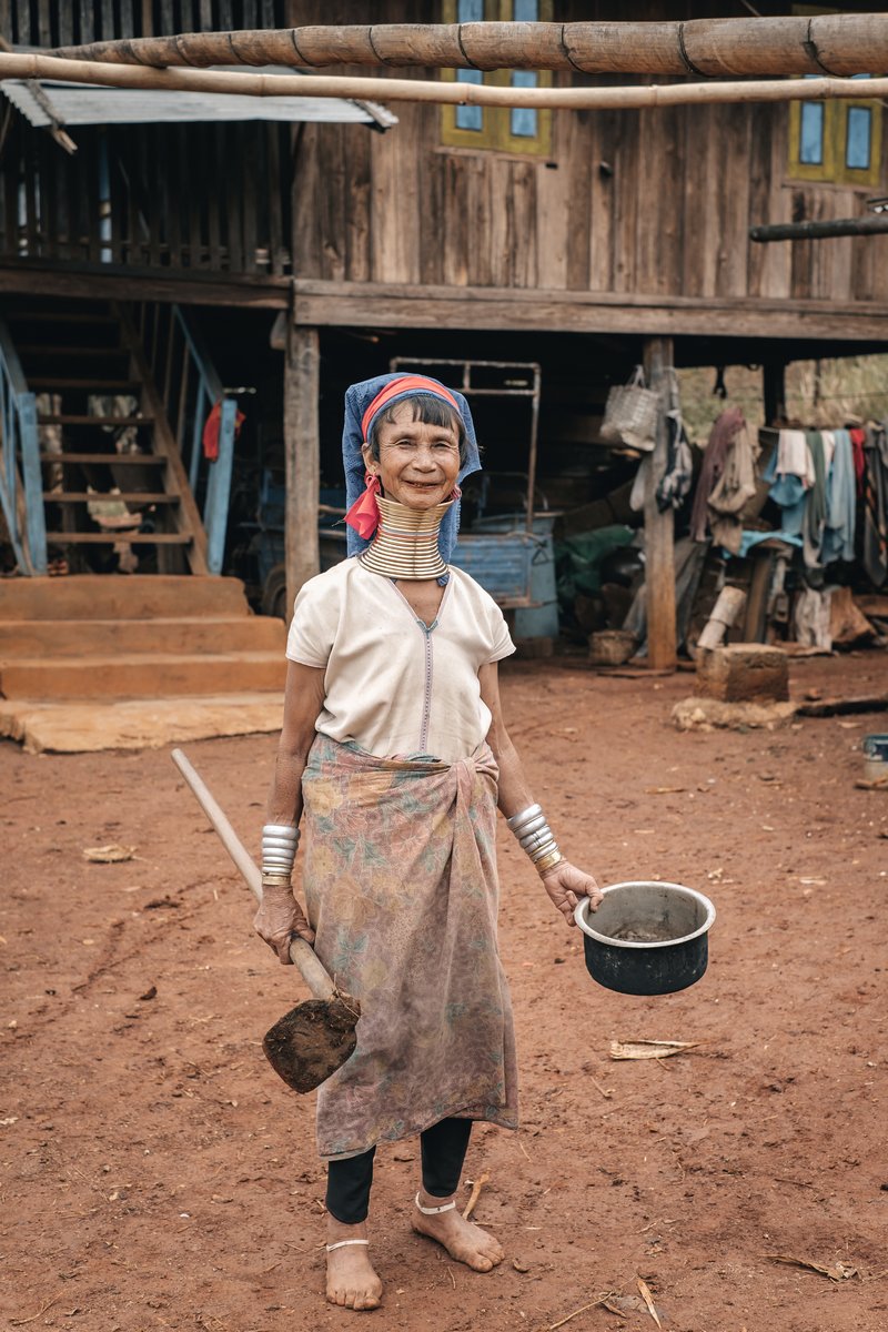 Pan Pet, Myanmar - May 25, 2016: Rural life of Padaung (Karen) hill tribe village in Myanmar. Senior long neck woman in brass rings around their neck doing home work Pan Pet, Myanmar - May 25, 2016: Rural life of Padaung (Karen) hill tribe village in Myanmar. Senior long neck woman in brass rings around their neck doing home work