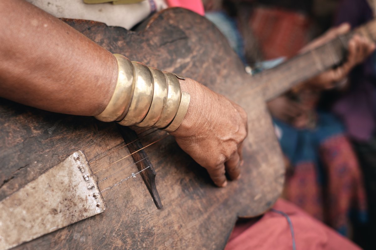 Pan Pet, Myanmar - May 25, 2016: Padaung (Karen) woman playing traditional guitar near the house, Myanmar